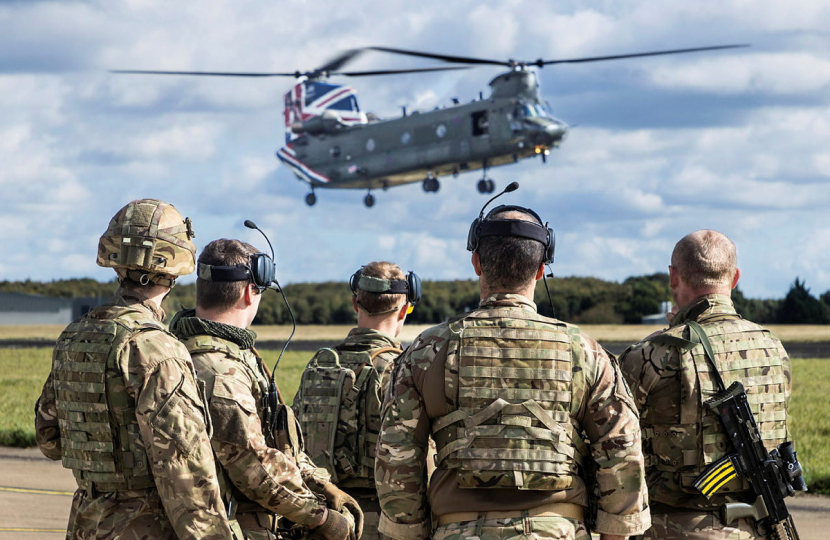 Picture of a group of soldiers watching an Apache Helicopter.